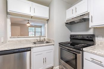 a kitchen with stainless steel appliances and white cabinets
